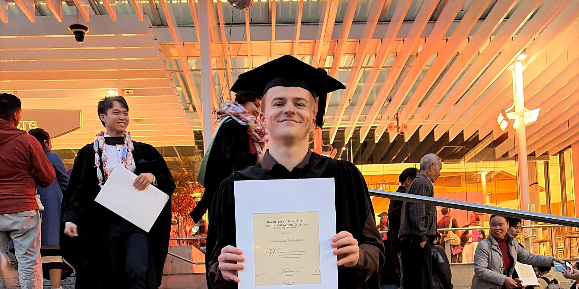 William Blake at graduation holding a Bachelor of Computer and Information Sciences certificate